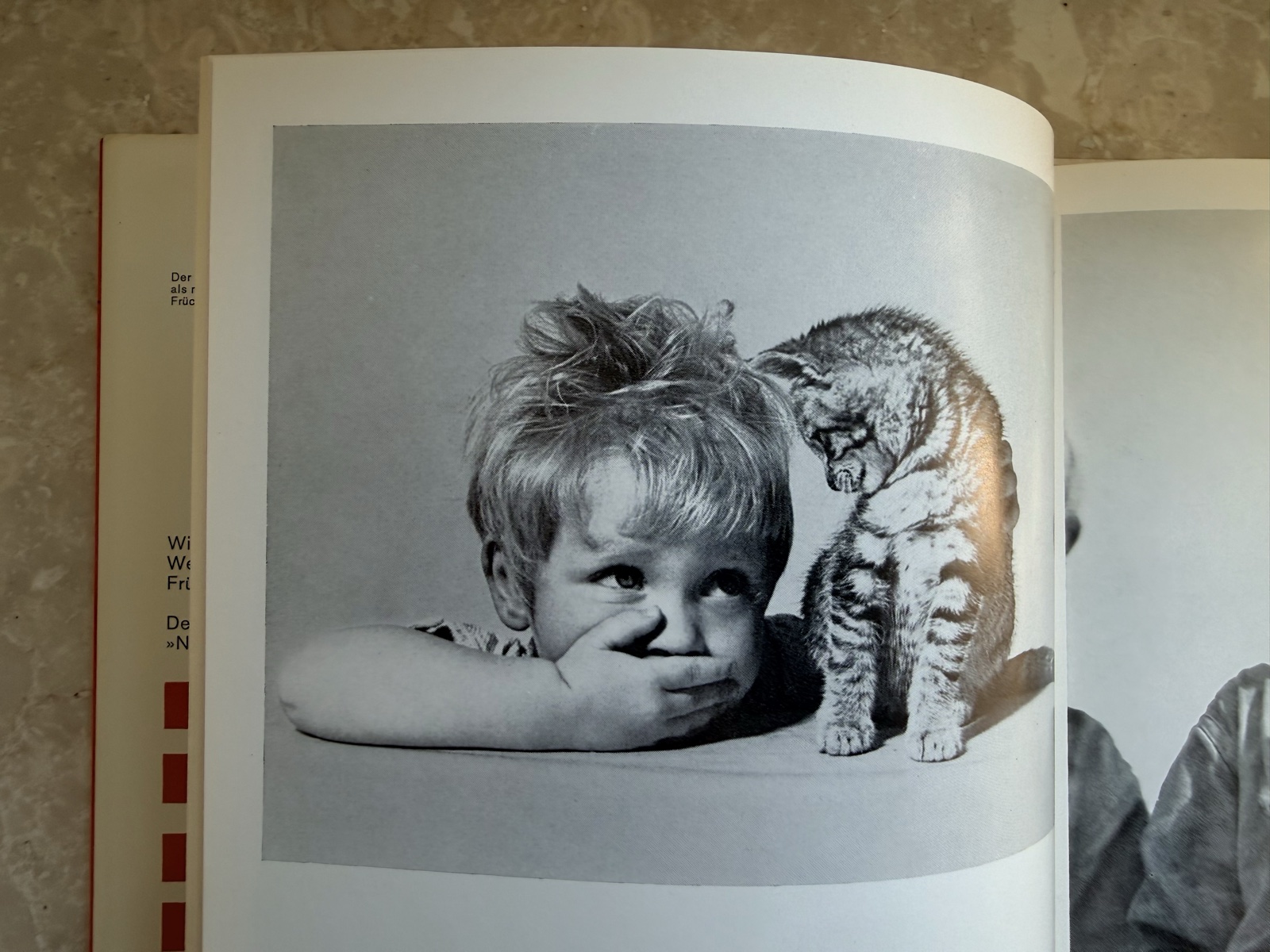 Rolf Poss als Kind mit einer Katze auf einer historischen Fotoseite